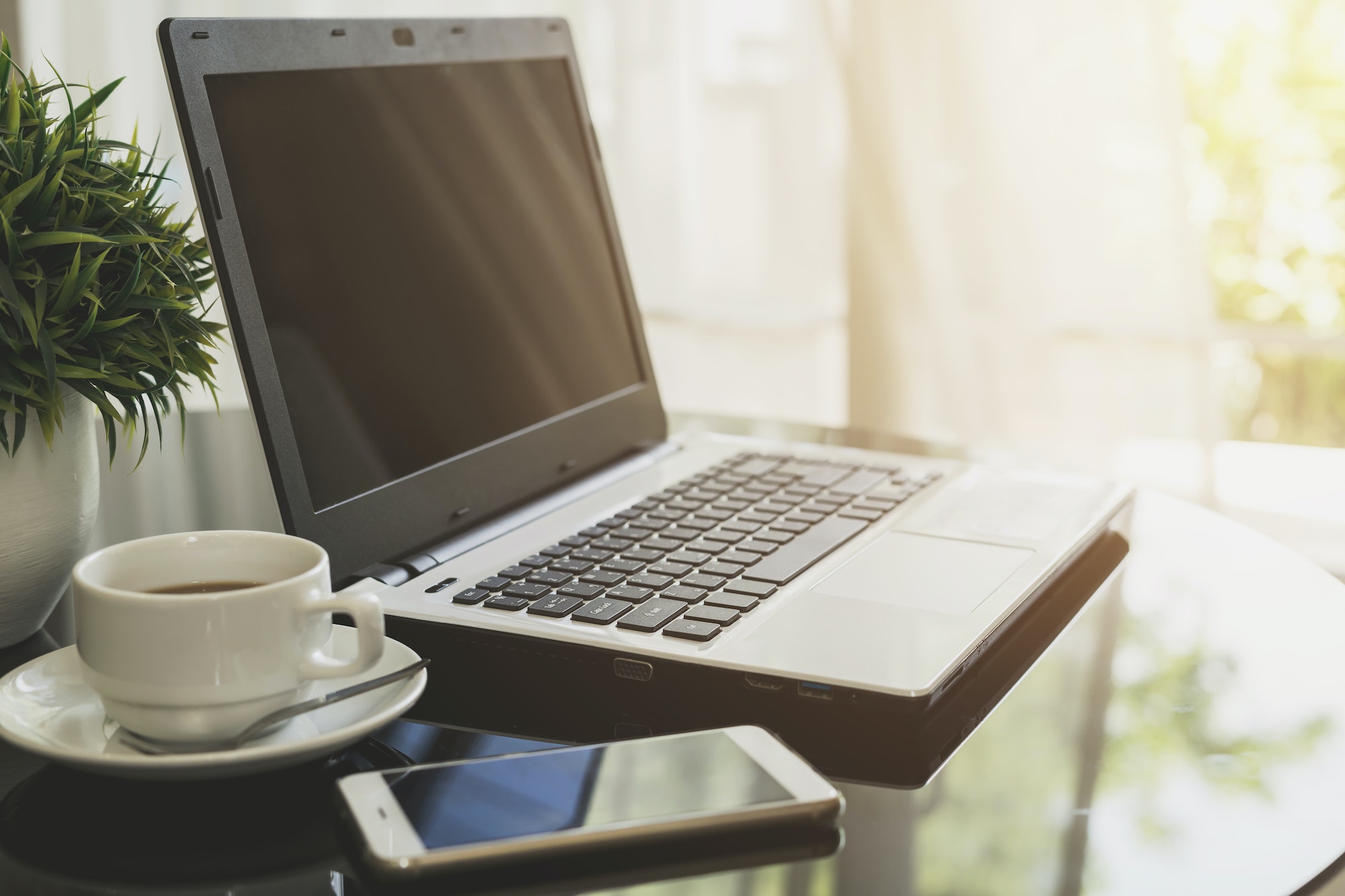 Laptop computer with smart phone and cup of coffee